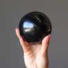 hand holding black tourmaline sphere