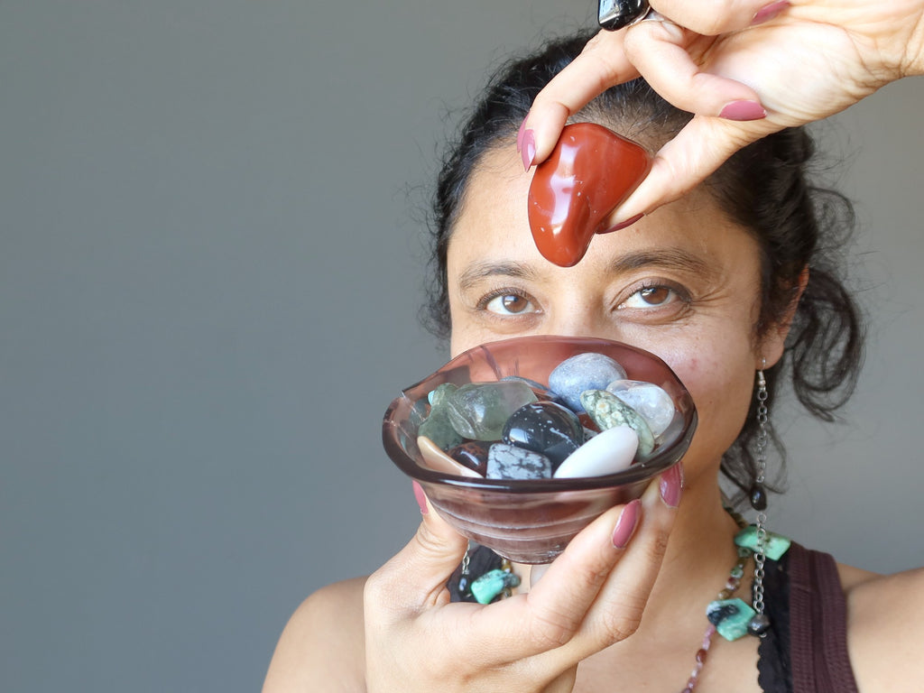 sheila of satin crystals holding a bowl of tumbled stones and a red jasper to her third eye