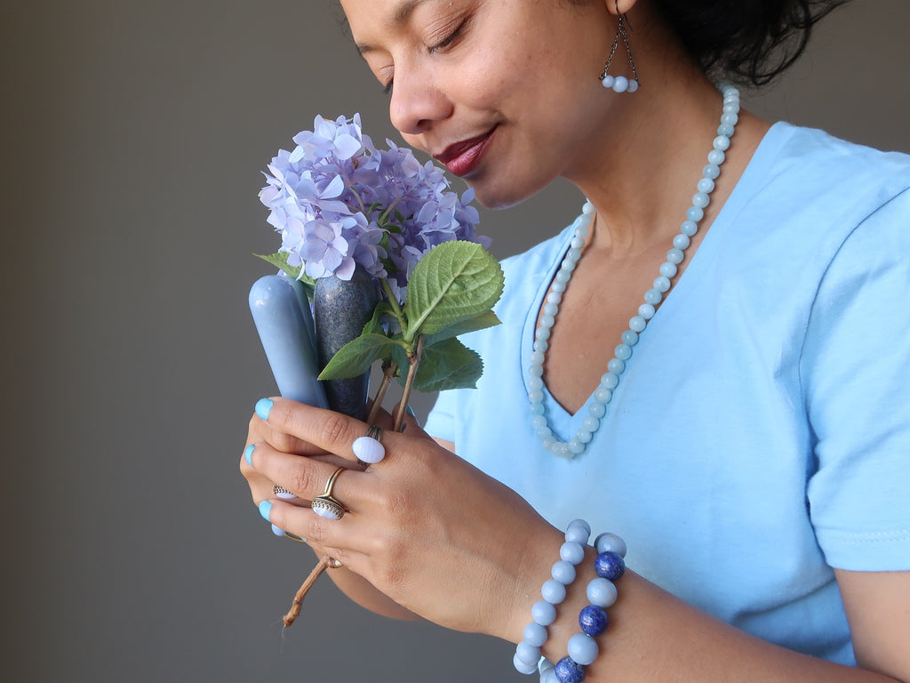 sheila of satin crystals holding a bouquet of flowers and angelite massage wands