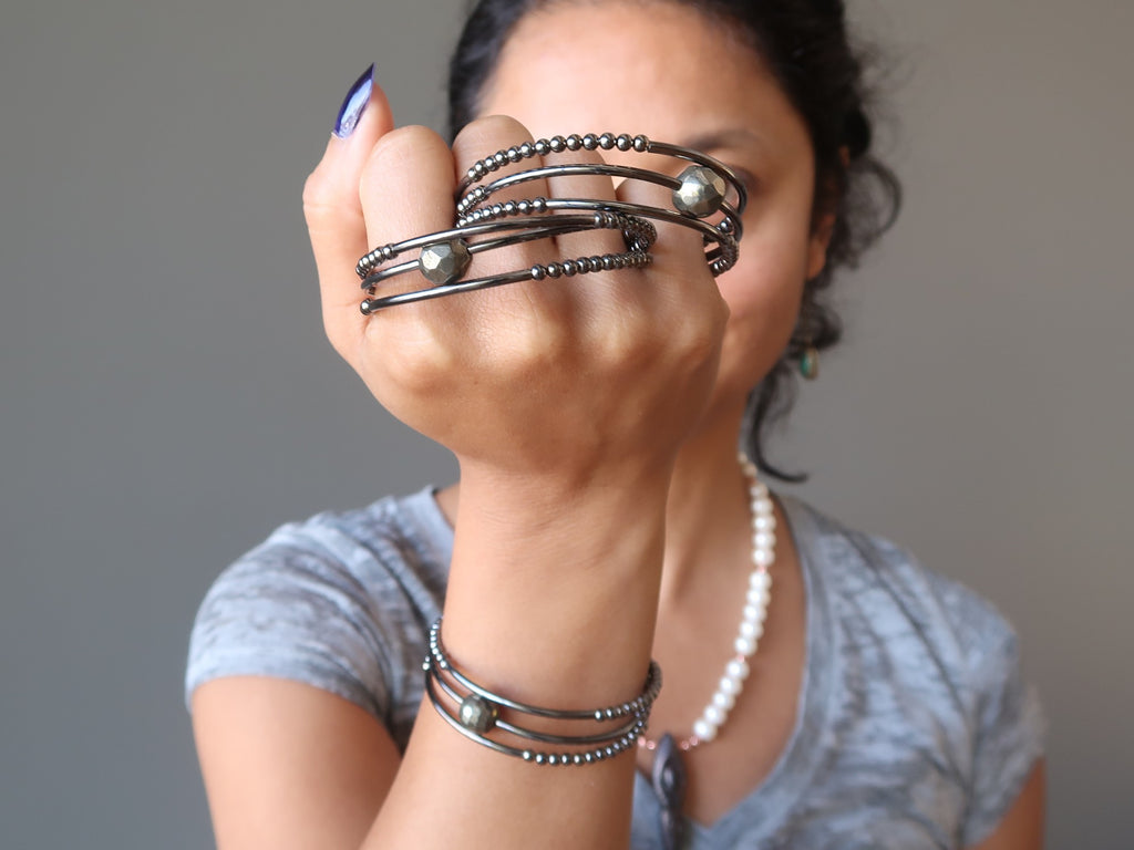 sheila of satin crystals holding up pyrite memory wire bracelets