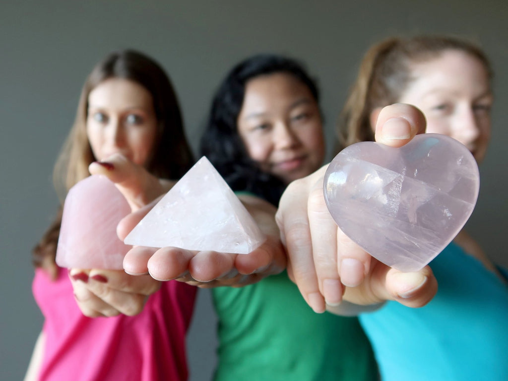 3 female models holding out rose quartz crystals