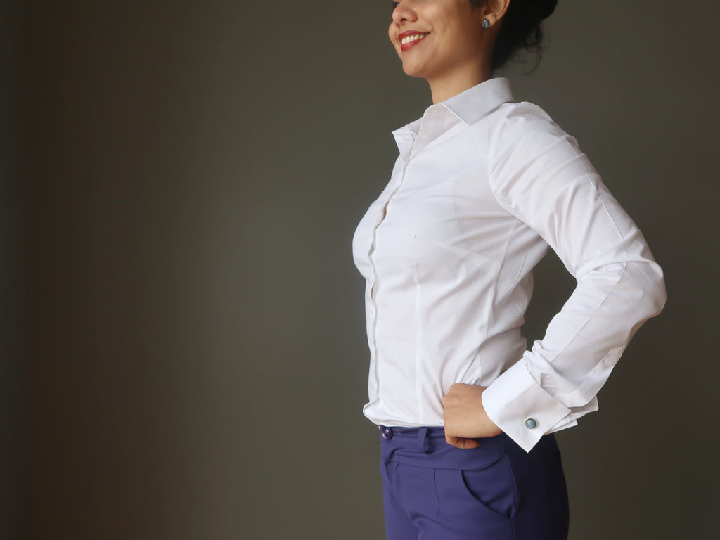 woman standing in cufflink shirt and blue pants