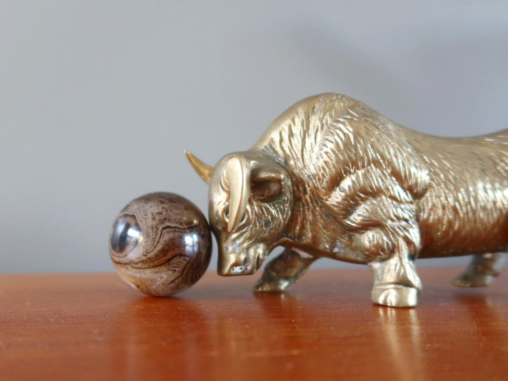 metal bull ox pushing a sardonyx sphere with its head