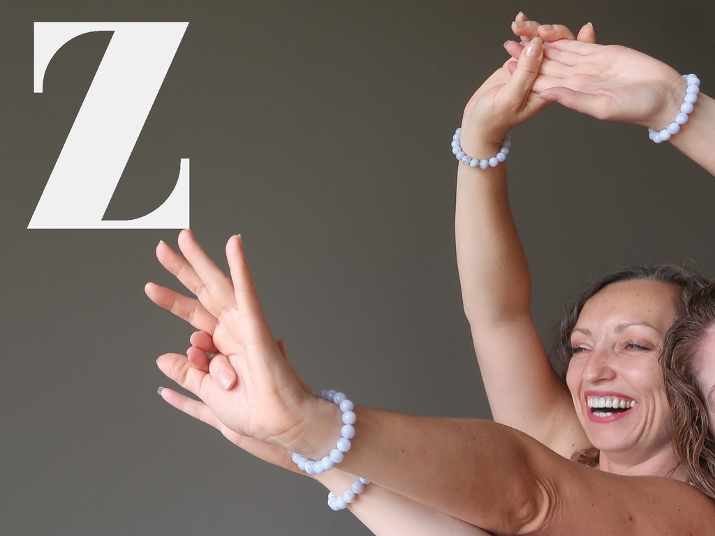 Zodiac bracelets: aleks and jamie of satin crystals with arms raised in a happy dance together