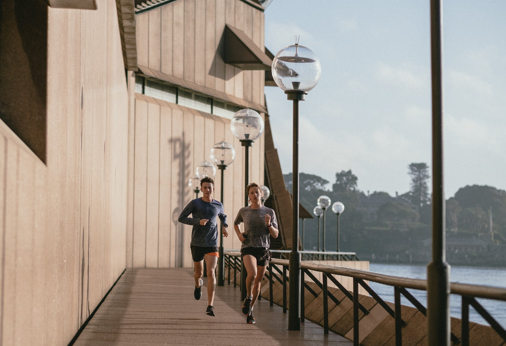 Man and woman doing a morning run by Sydney harbour