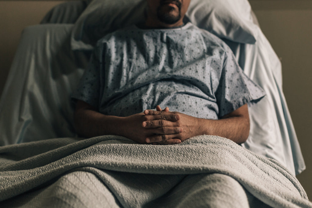 a man propped up in hospital bed sick needs sleep