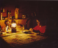 Janet Rice-Bredin working on a latch hook rug by the light of a Coleman lantern in a remote cabin in Northern Ontario Canada in 1976