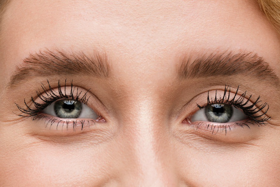 woman smiles after applying fiber lashes