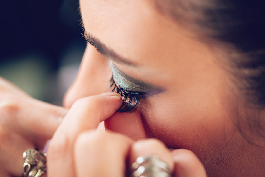 woman applying fake eyelashes