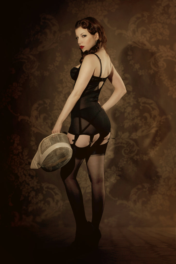 Retro black lace and powernet corselette with vintage sepia background and fencing accessories