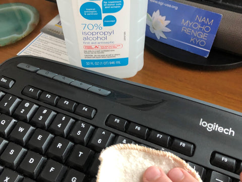 wiping keyboard clean with rubbing alcohol