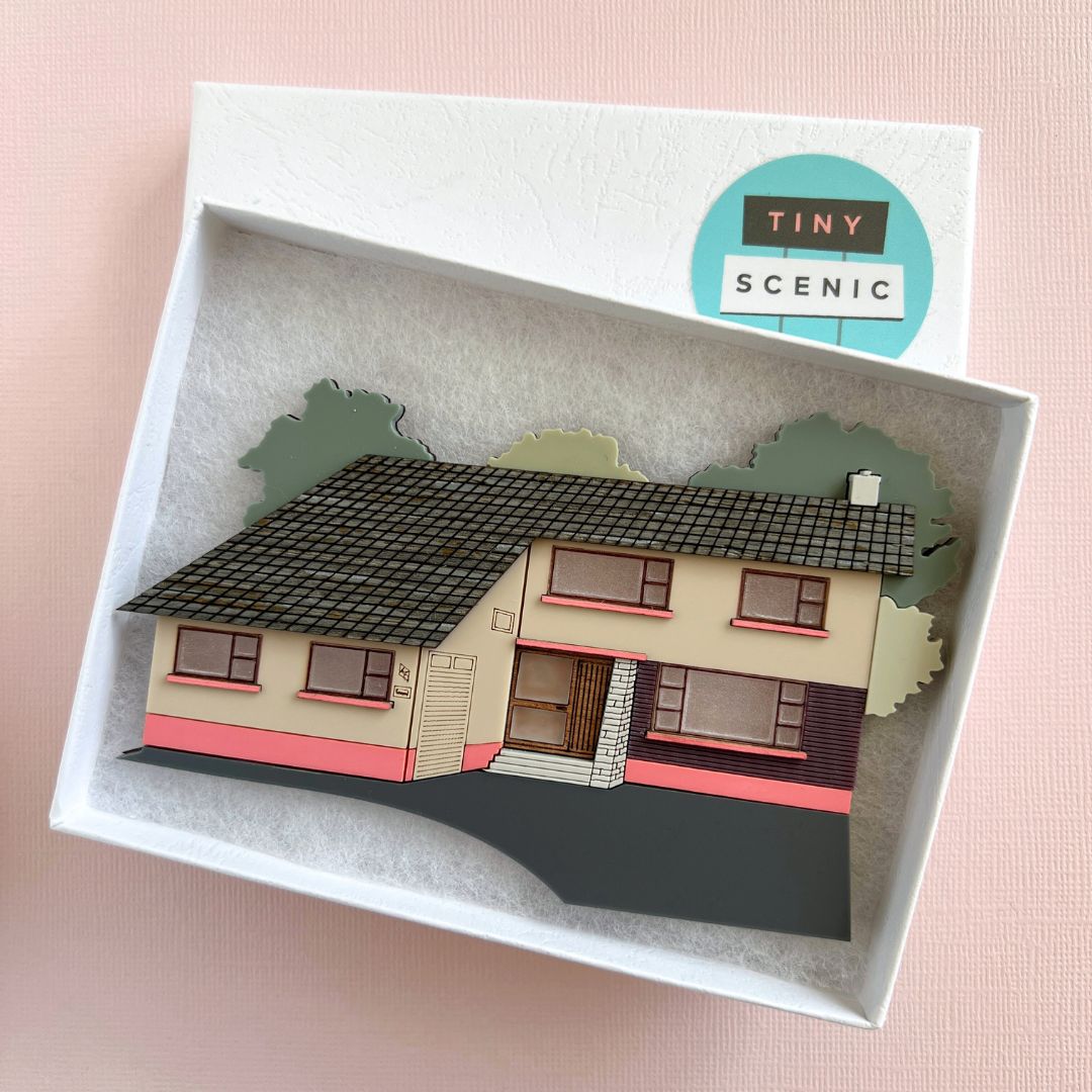 A miniature house facade made from acrylic nestled in a padded gift box
