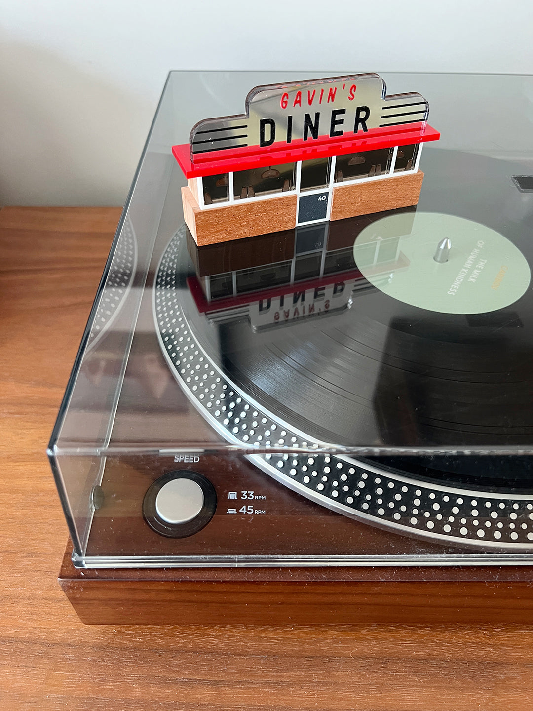 A miniature American diner ornament, photographed on top of a vinyl turntable