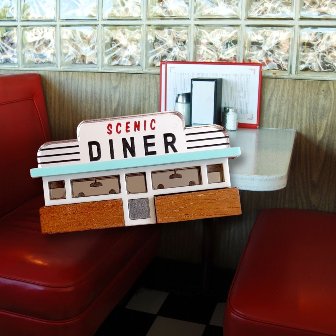 wood and acrylic american diner brooch with a photo of a diner booth behind