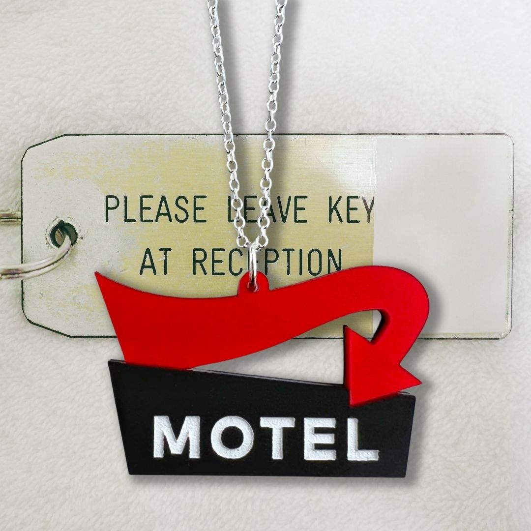 motel sign necklace with red arrow with a hotel key in the background