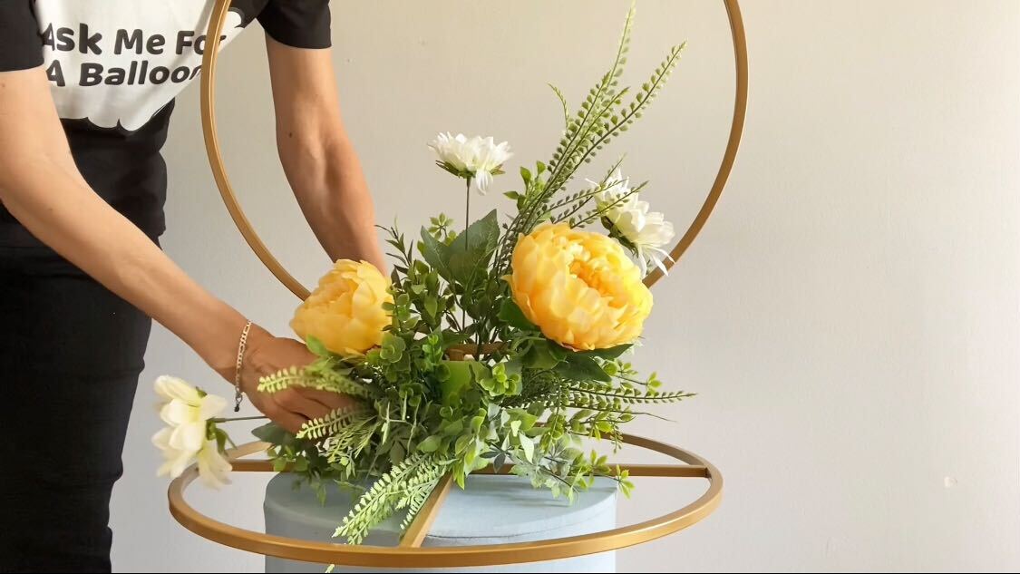 Person arranging the floral decor onto the flower stand