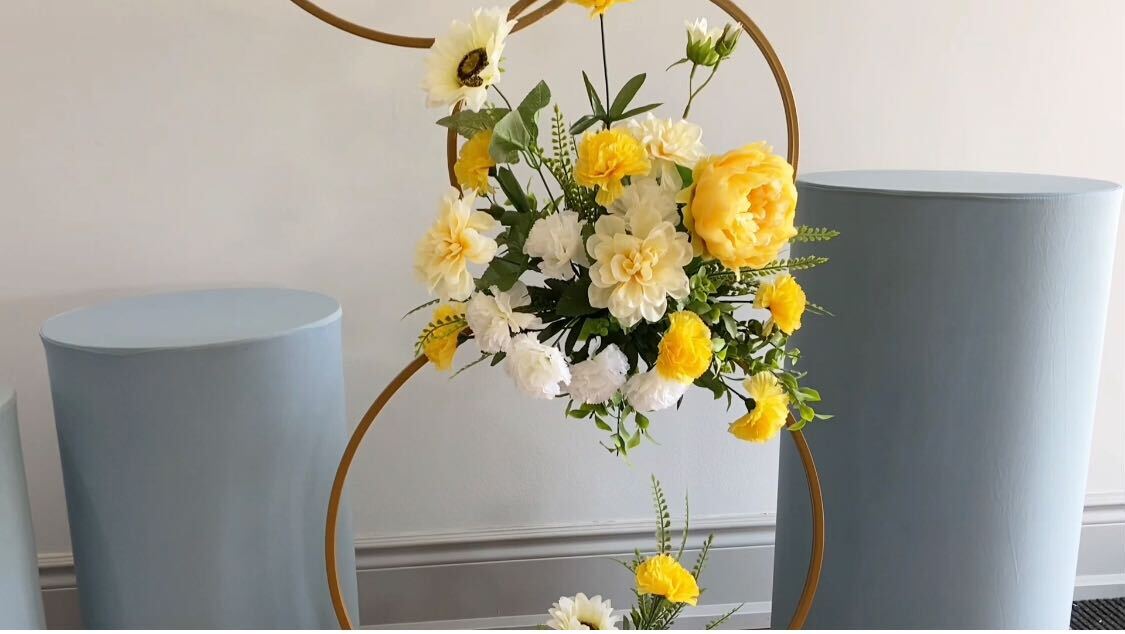 Floral hoop decor in the middle of cylinder display stands
