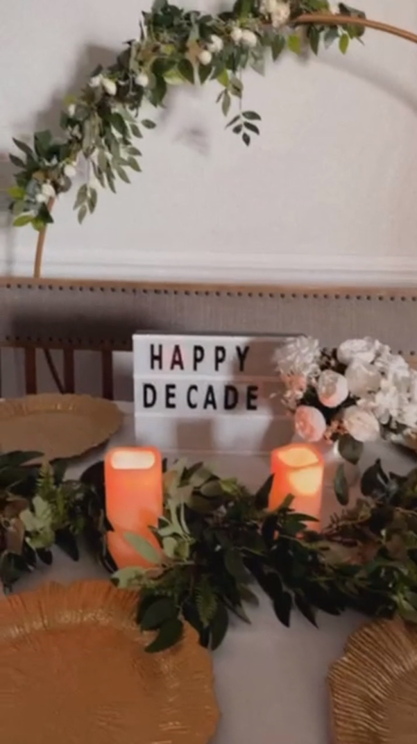 Greenery vines laid on the table with flowers and candles