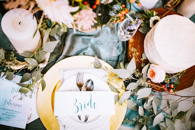 Elegant wedding tablescape, gold-rimmed plate, and romantic candle.