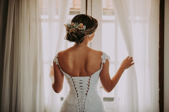 Bride holding the sheer curtain drapes