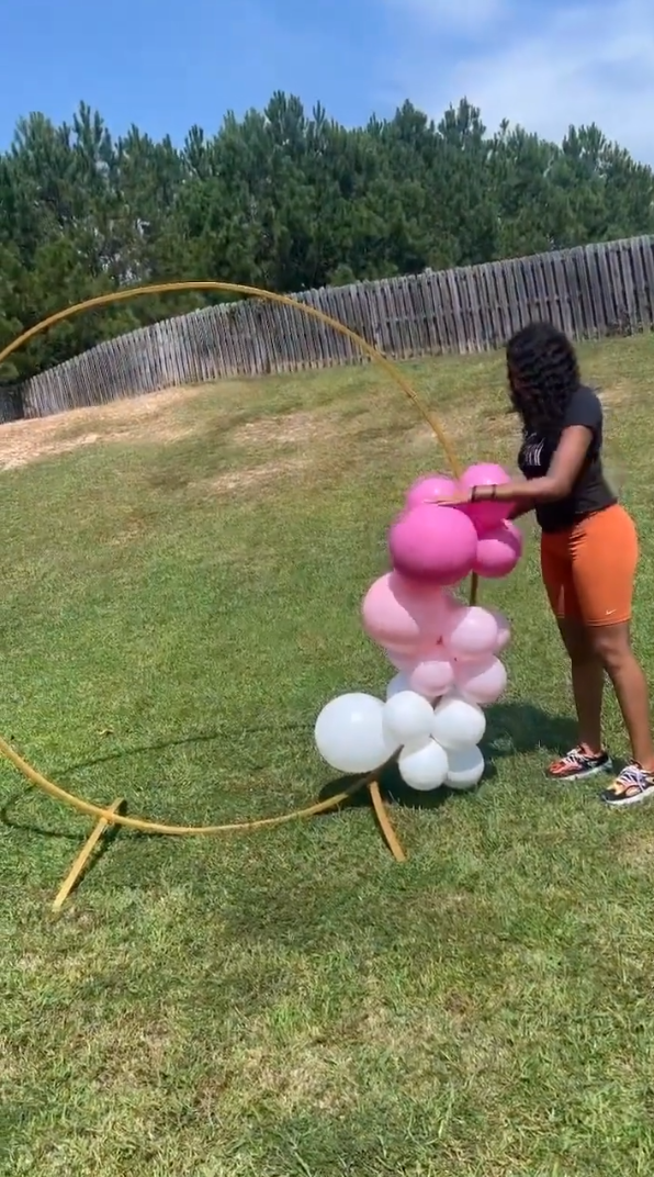 Person attaching the balloons to the backdrop stand