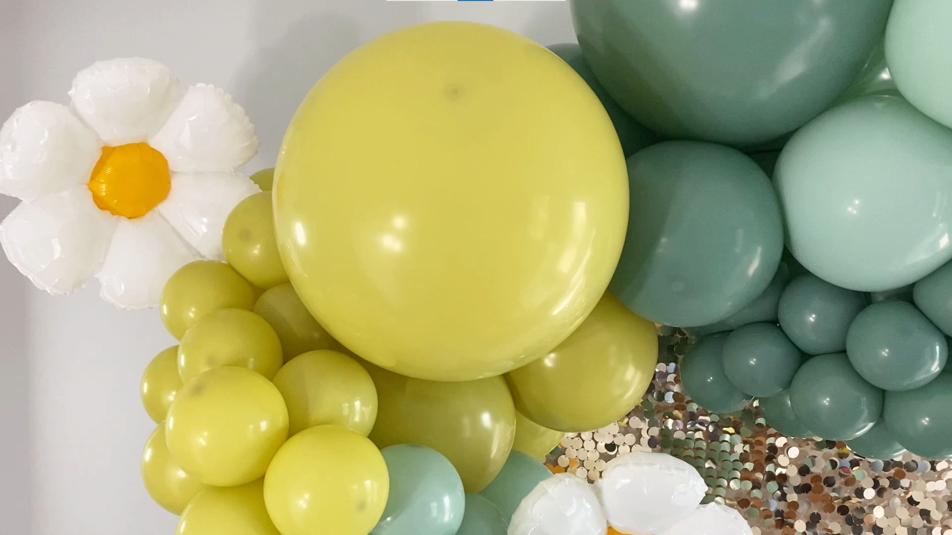 Focus on the gold and green balloon garland