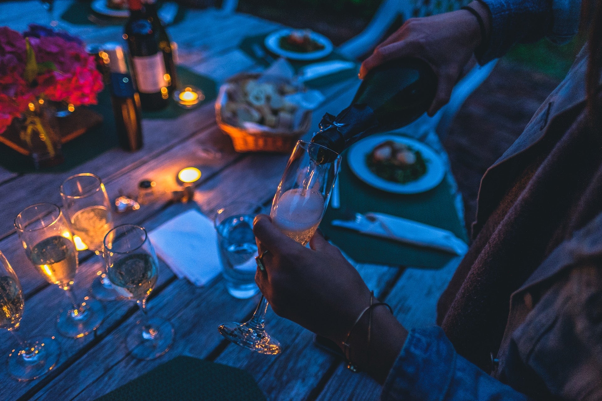 Person pouring white wine into a glass