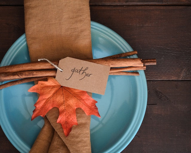 Blue disposable plate with a cloth napkin and fall leaf