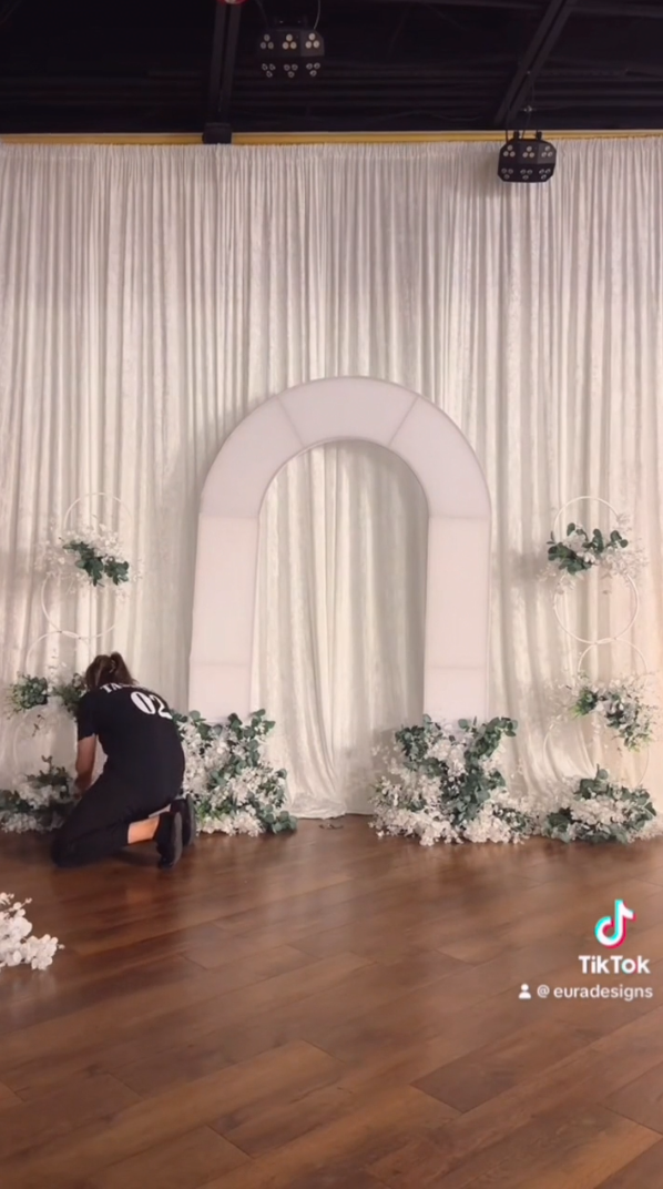 Wedding backdrop with metal arch, hoop stands, and flower decor