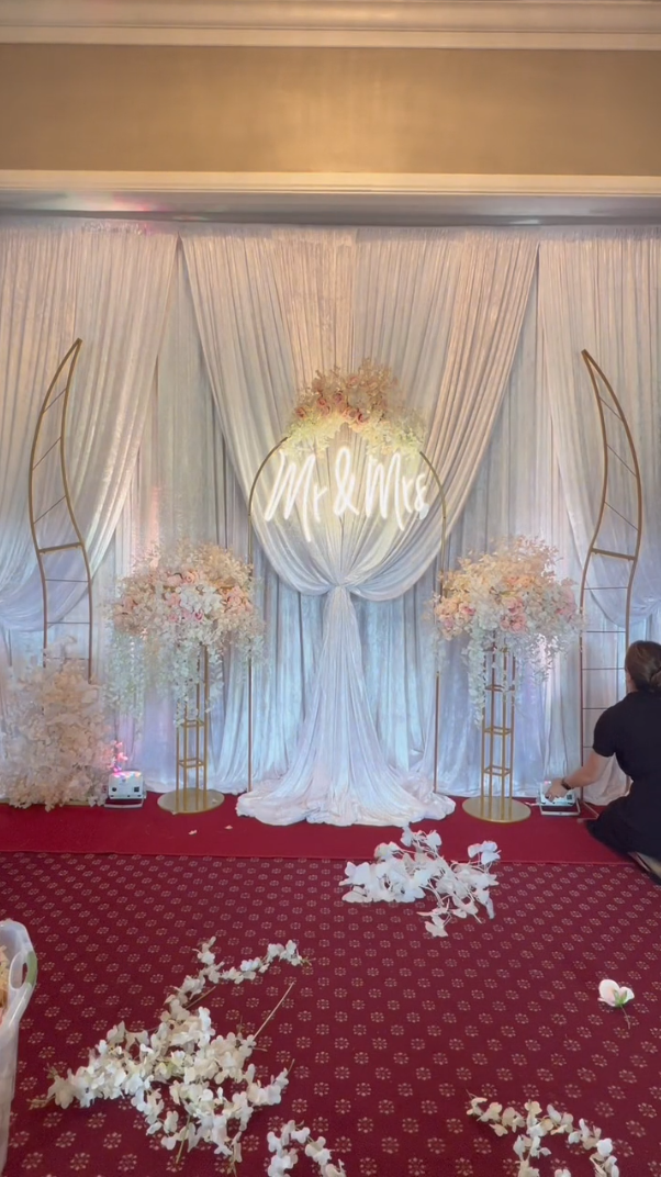 Person adding artificial flowers to the frame stands