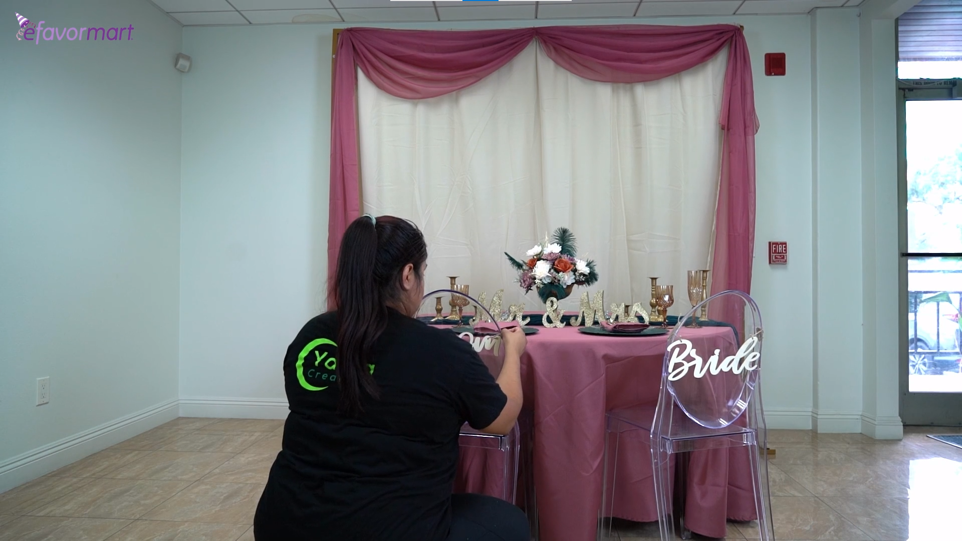 Person installing the bride and groom signs to the acrylic chairs