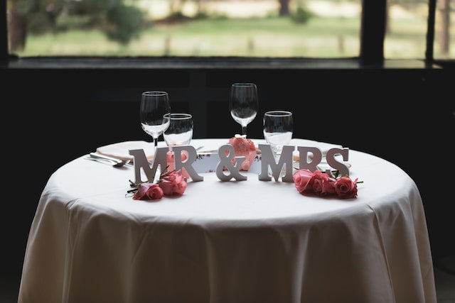 Wedding table with tablecloth, wine glasses, and freestanding letter props