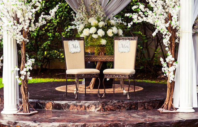 Bride and groom chair with flowers and greenery decor