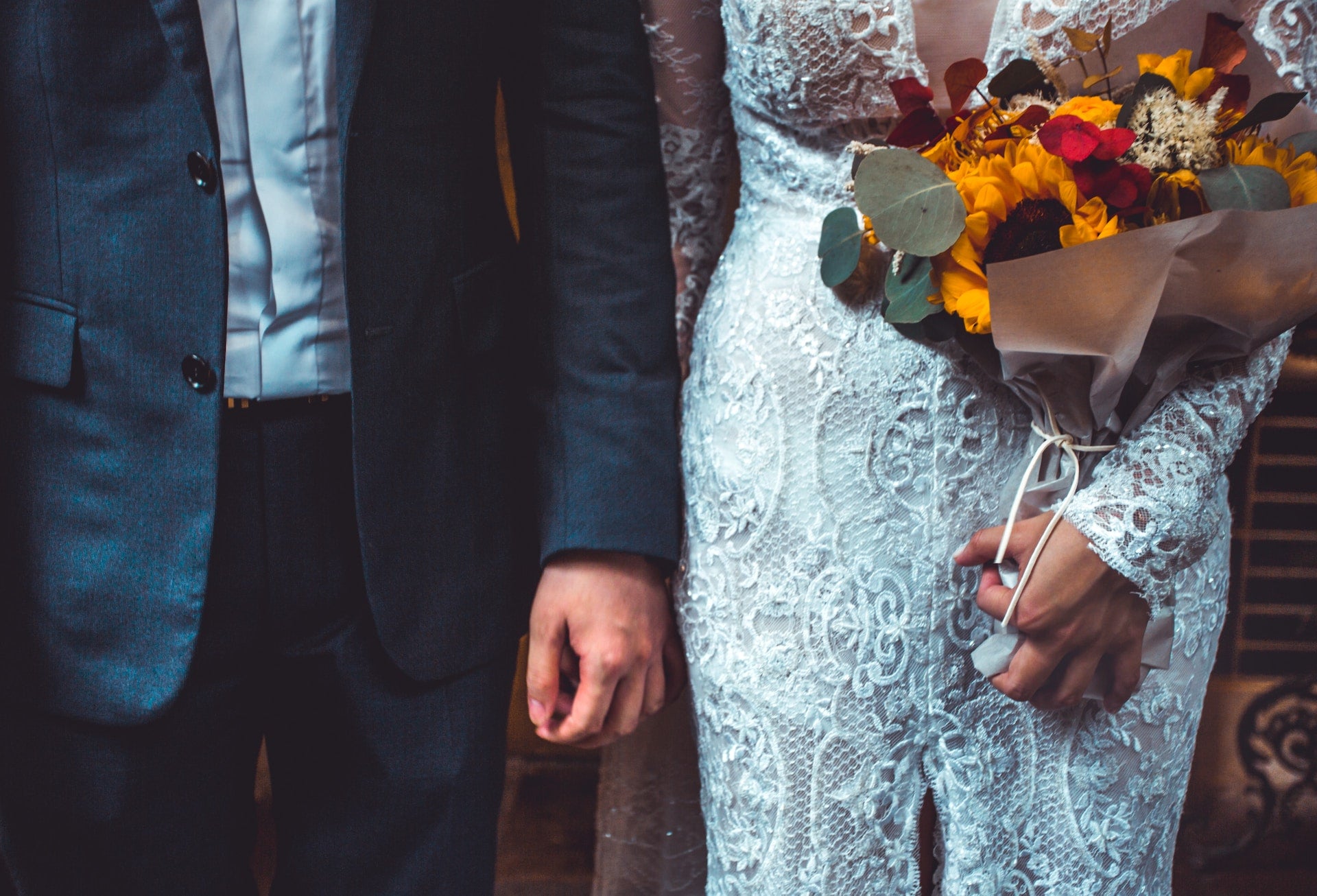 Groom standing next to a bride holding a bouquet