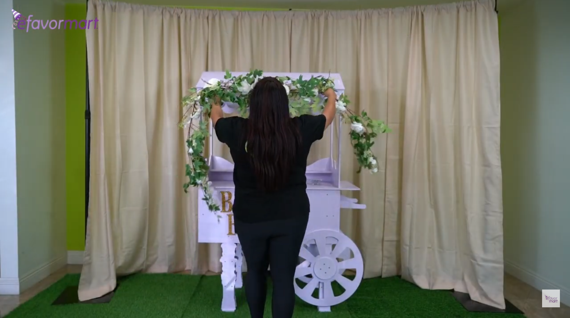 Image of a woman decorating a cart with greenery as Mother's Day decor.