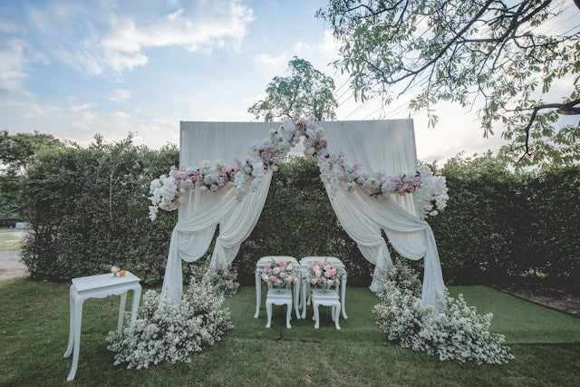 White and pink flower arch with curtain drapes