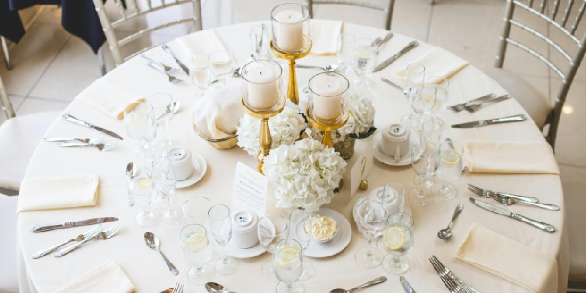 simple table seting with napkins, candles, flowers, and cutlery