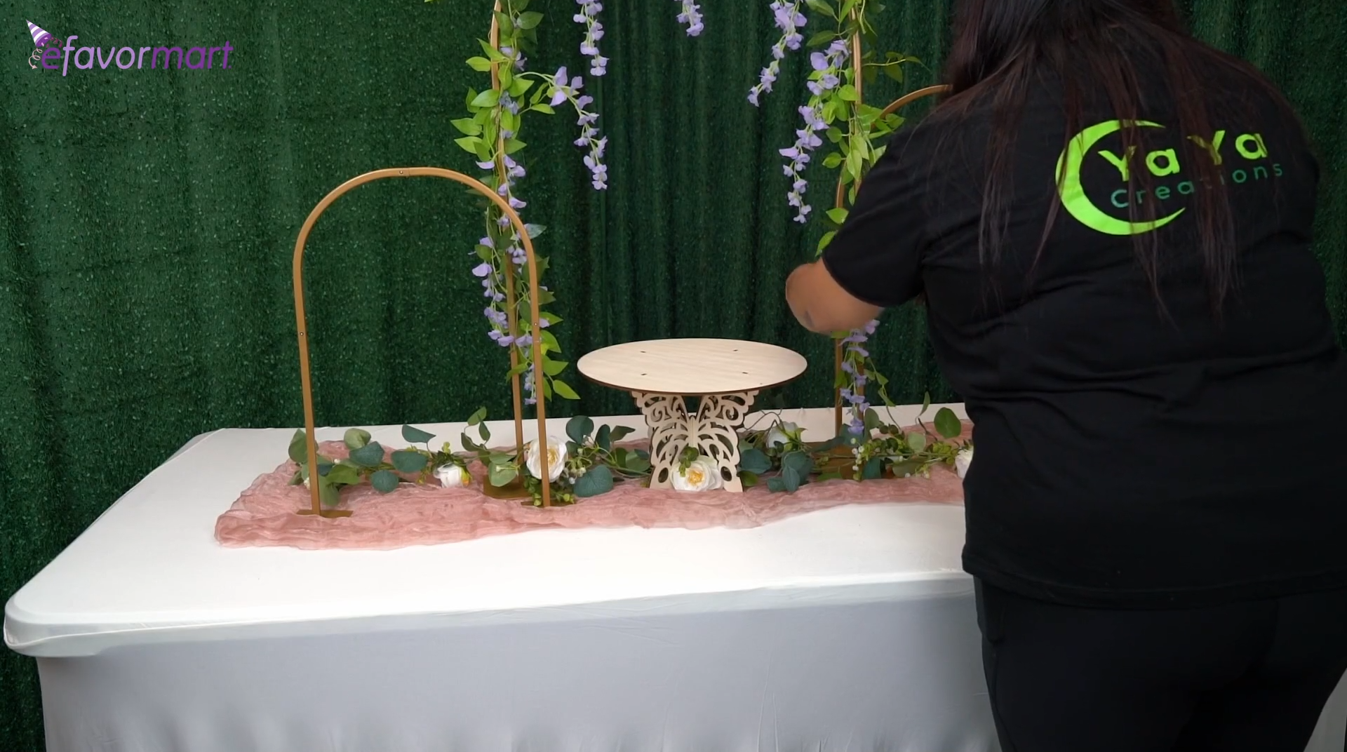 Spring table setup with table runner, metal arches, and greenery