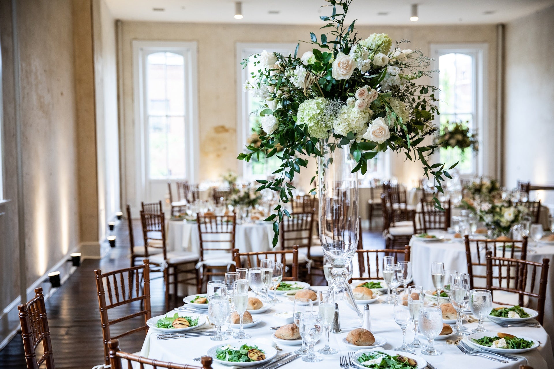 Formal table setting with flowers in a tall glass vase