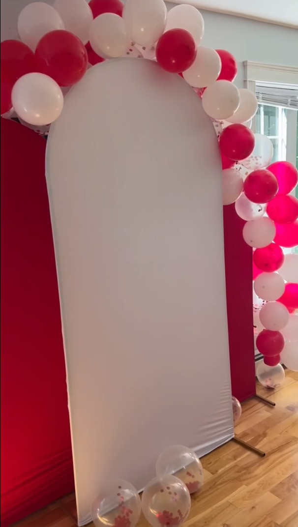 Backdrop stands adorned with red and white balloons