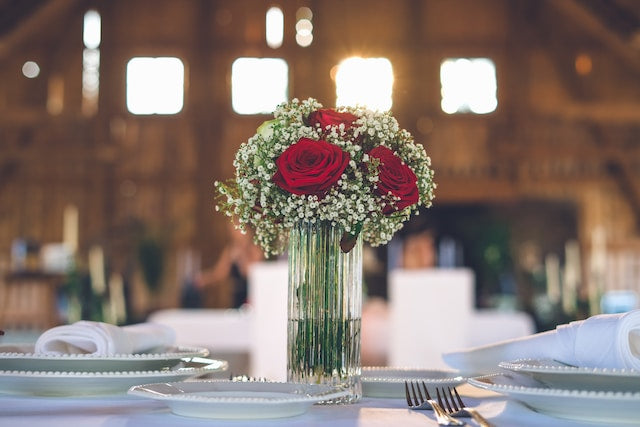 Red rose and other flowers in a glass vase