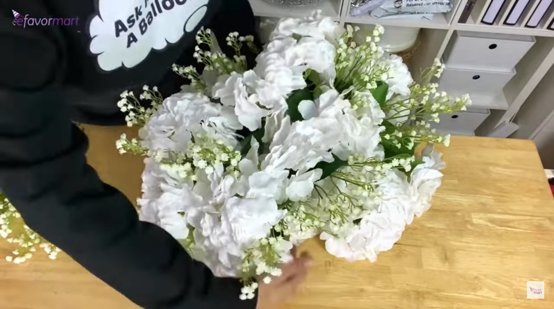 Arranging a wedding floral centerpiece on a table.
