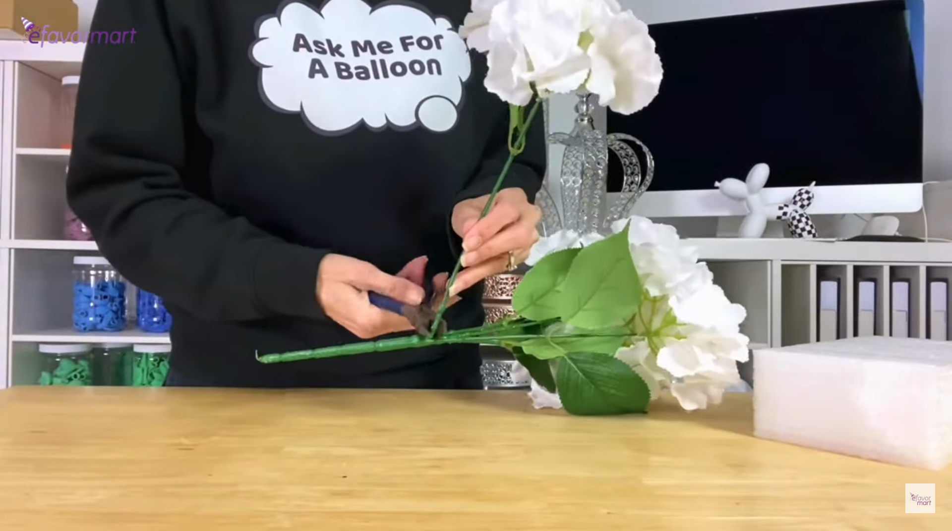 Person preparing flowers for a floral arrangement