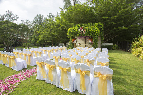 chair covers over chairs on grass at a wedding