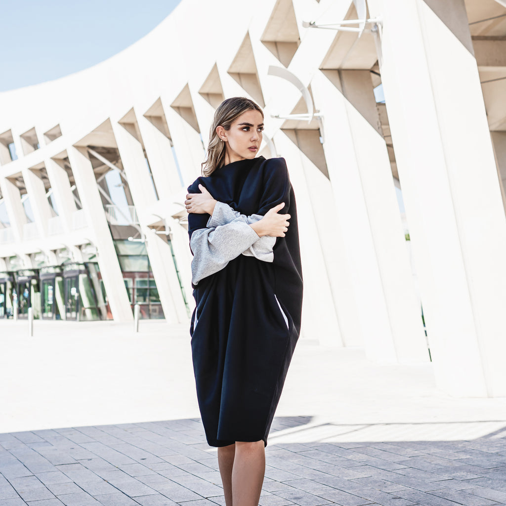 A woman wearing a long sweater dress in organic cotton with long sleeves by Malaika New York