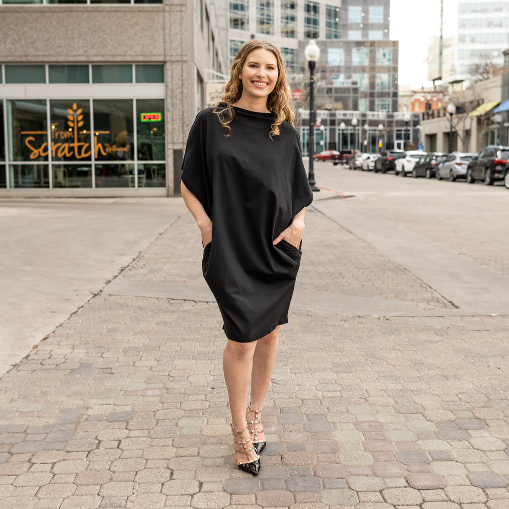 A woman wearing a knee length sustainable shift dress with pockets in organic cotton by Malaika New York