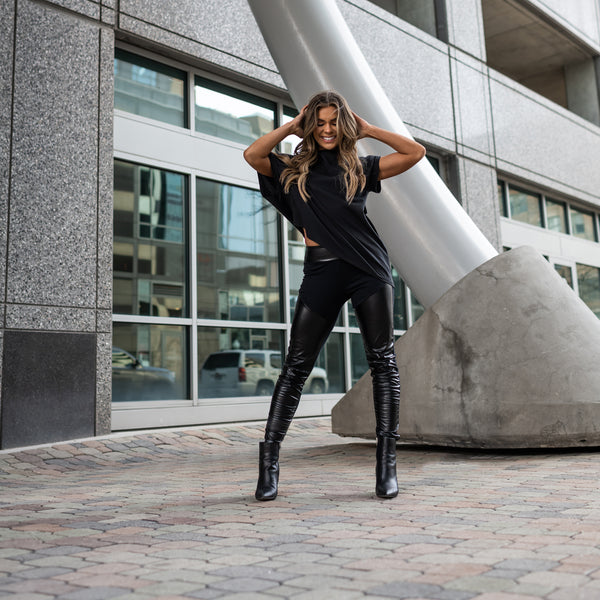 A woman wearing faux leather leggings by Malaika New York