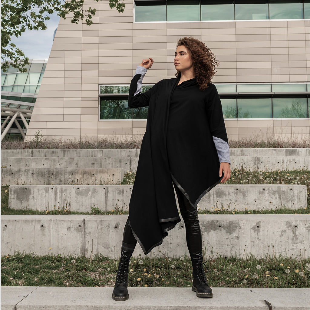 A woman wearing a long black sustainable waterfall cardigan in organic cotton by Malaika New York