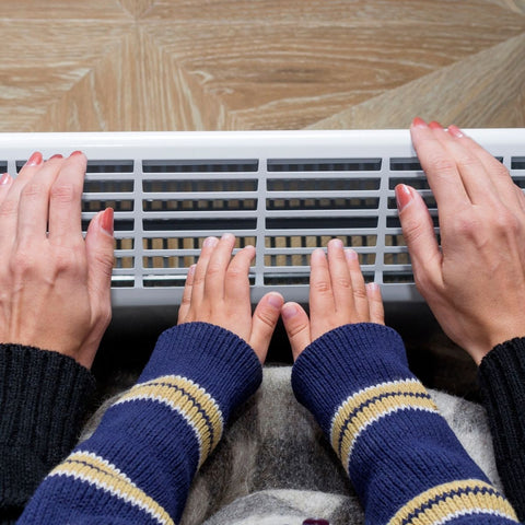 mum and babies hands on heater