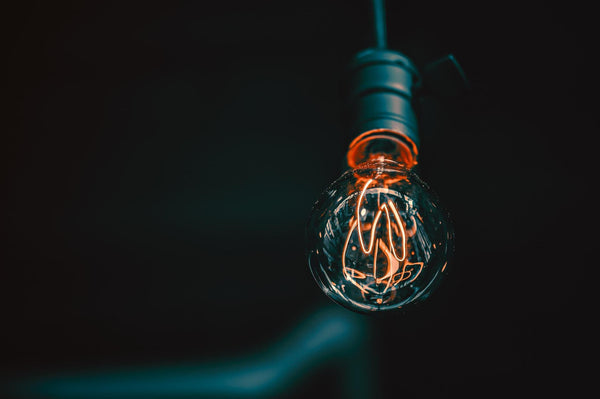 Lightbulb on Black background. Red Element 